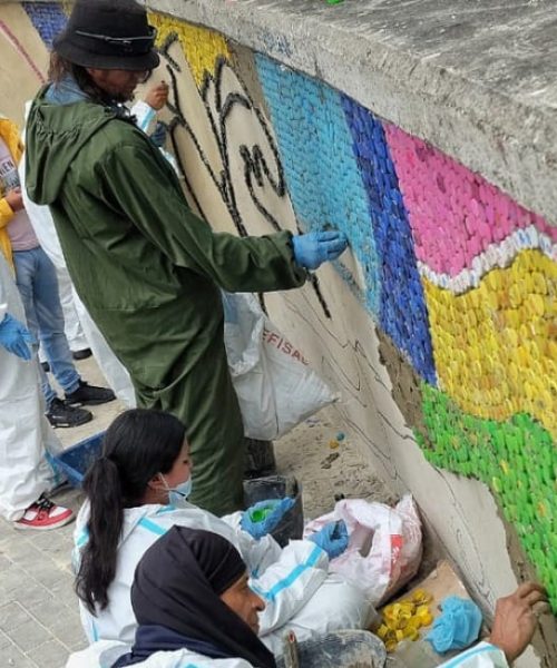 Exhabitantes de calle crean mural de tapas para Bienal BOG25 en TransMilenio