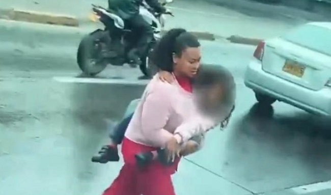 Peligroso cruce: mujer atravesó la NQS con una niña en brazos